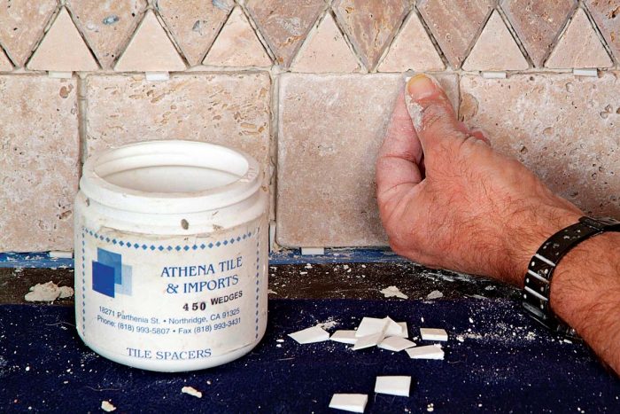 Use small flexible wedges to adjust the alignment of tiles on a vertical surface.