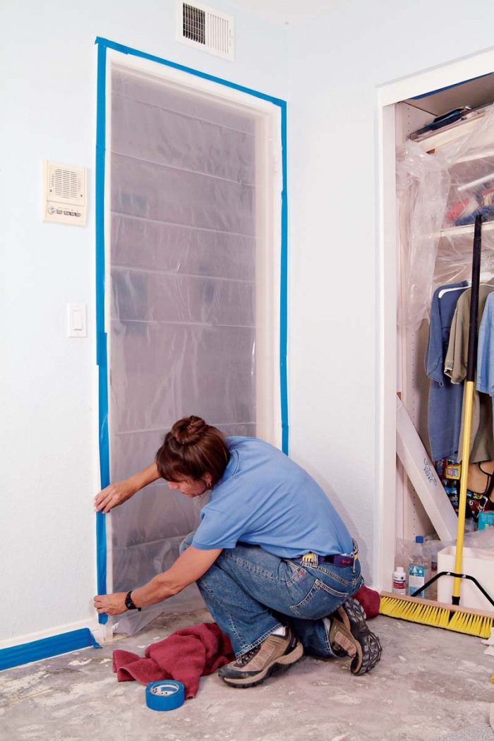 Tape plastic sheeting to the door frame using blue painter’s tape.
