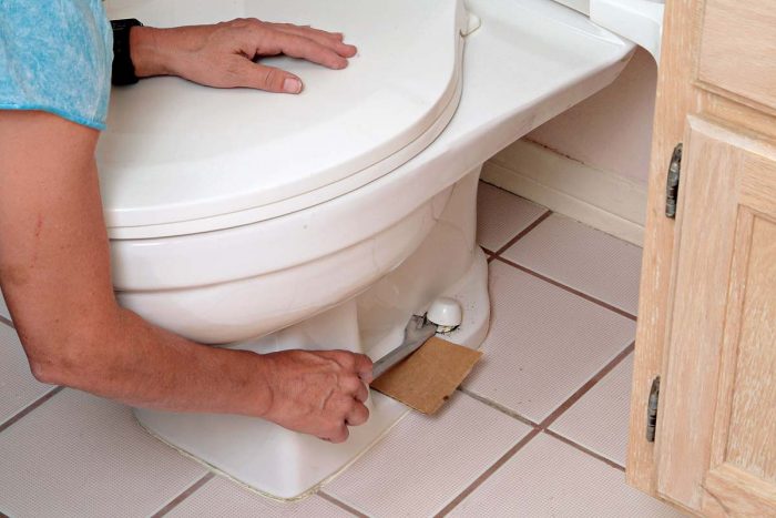 Use a piece of cardboard to protect the toilet as you pop off the bolt caps.