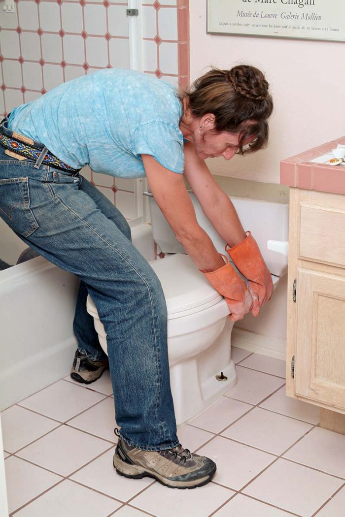 Rock the toilet side to side carefully to loosen the seal, grout, and caulking.