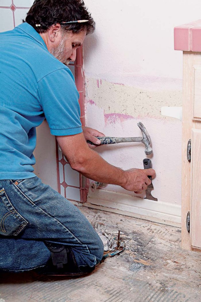 Break the caulking at the top of the baseboard with a putty knife.