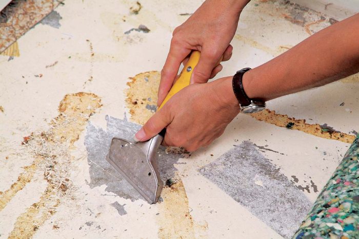 Use a wall scraper to remove any loose paint or glue from the concrete slab.