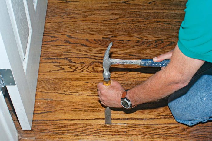 Use a sharp wood chisel and hammer to cut through the finished floor.