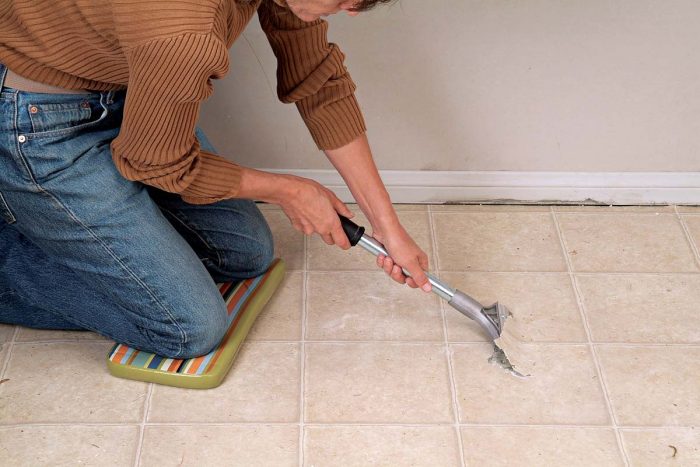 Slice a channel with a razor knife. Push the floor scraper under the flooring.