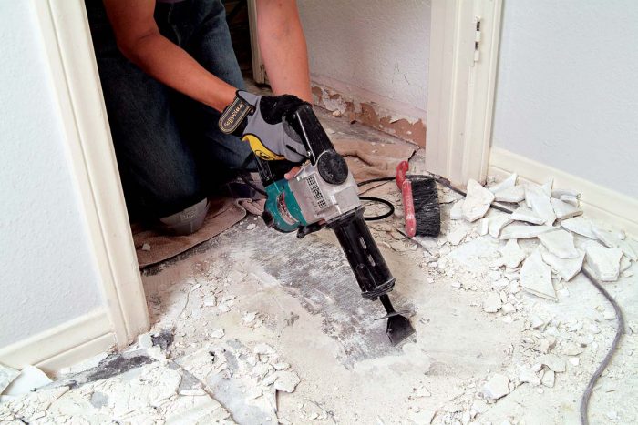 A flat-tipped chisel and a chipping hammer remove all remaining thinset from the concrete.