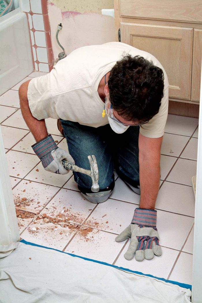Start demolition by hammering a channel into the tile, to provide a starting place for a prybar.