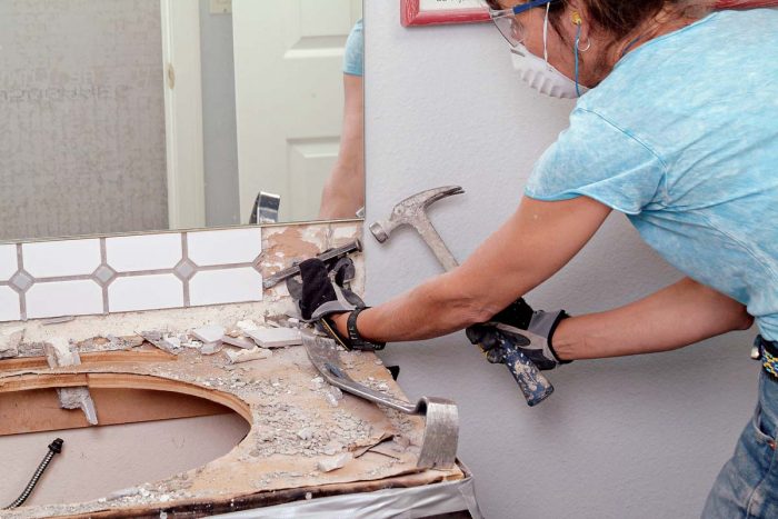 Carefully remove a tiled backsplash by starting at the edge, then work inward.