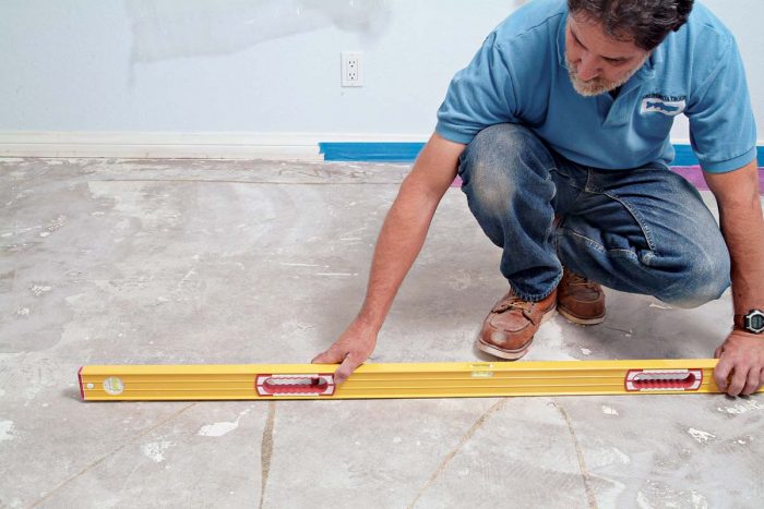 Use your level to check the concrete slab for hills or valleys before you start any tile work.
