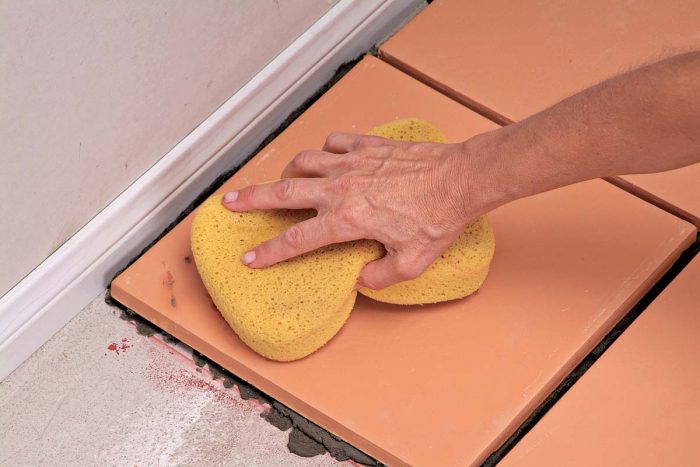 Use a damp sponge to immediately wipe away thinset drips from the face of the tile.