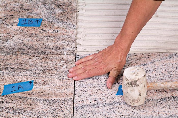 If you find a high spot, adjust the tile with a mallet or your fingertips.