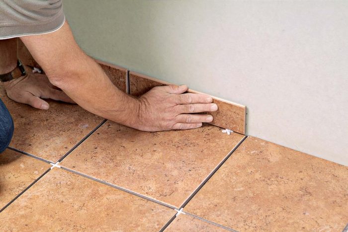 Press the tile base onto the wall, using spacers to keep the tops even to one another and to allow a caulk joint below.