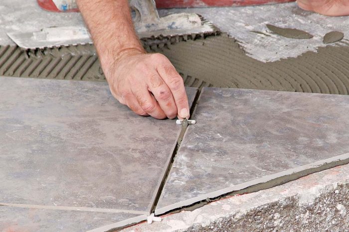 Use a tile spacer to remove excess wet thinset from between newly set tiles.