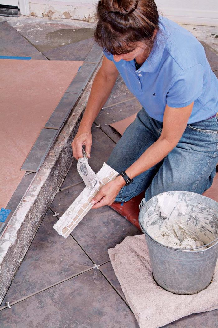 Back-buttering each bullnose trim tile ensures that its bond with the concrete floor will be strong.