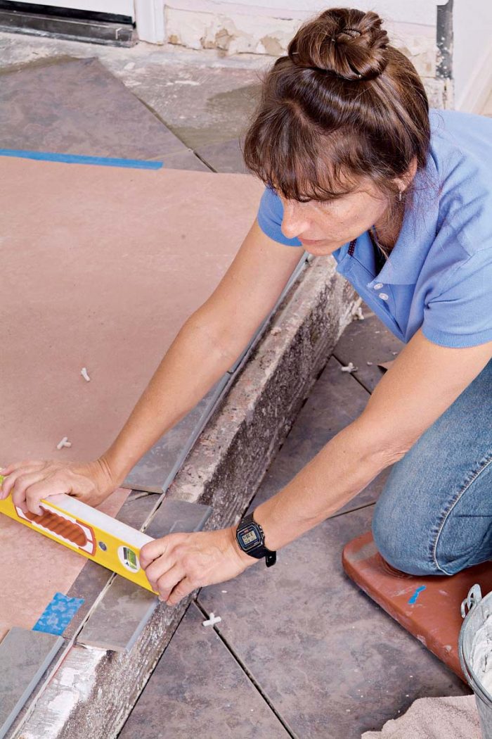 Use a small level to keep the bullnose tiles flat and even with the adjacent flooring.