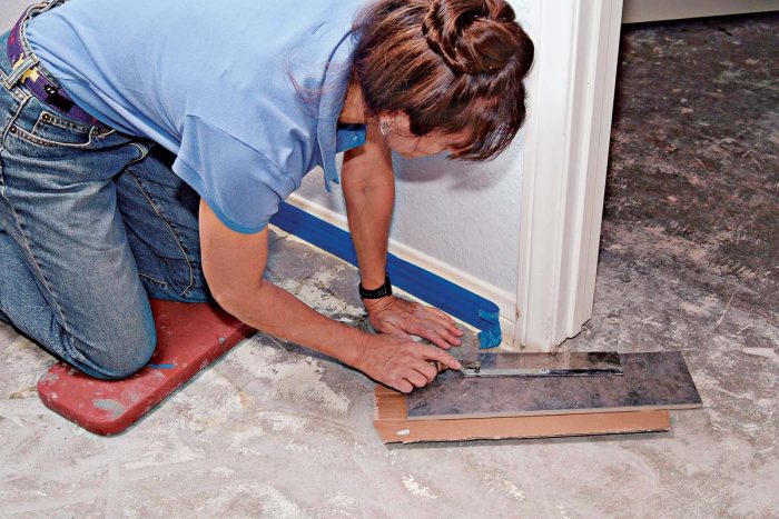 To set tile around doorways, first cut off the door casing, using a scrap tile, wood, or cardboard shim to support the saw.
