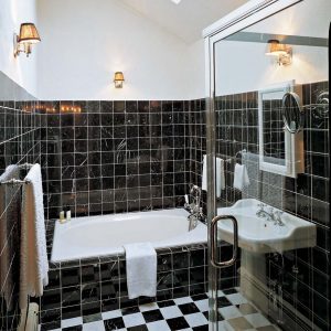 The solid color of the wall in this bath contrasts with the dark and light pattern on the floor.