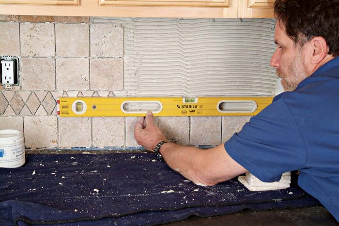After setting the first row of tiles, use a level to check for straightness. Add wedges to adjust tile height as necessary.