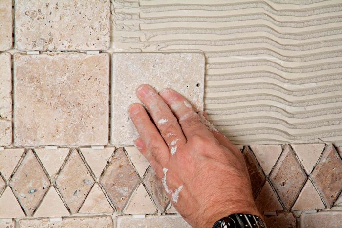 Press each tile firmly into the wet thinset on the wall.