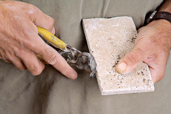 Use a pair of tile nippers to shape and rough up the otherwise sharp cut edge of a tumbled tile.