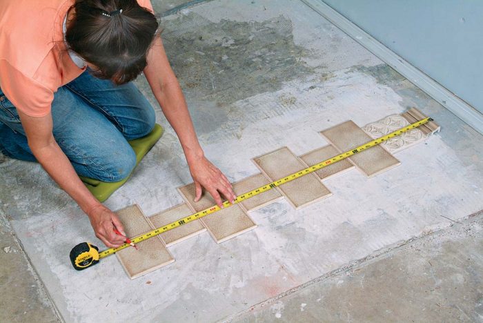 Lay out your pattern and measure from the top trim tile down. Mark the tile that will be at the floor.