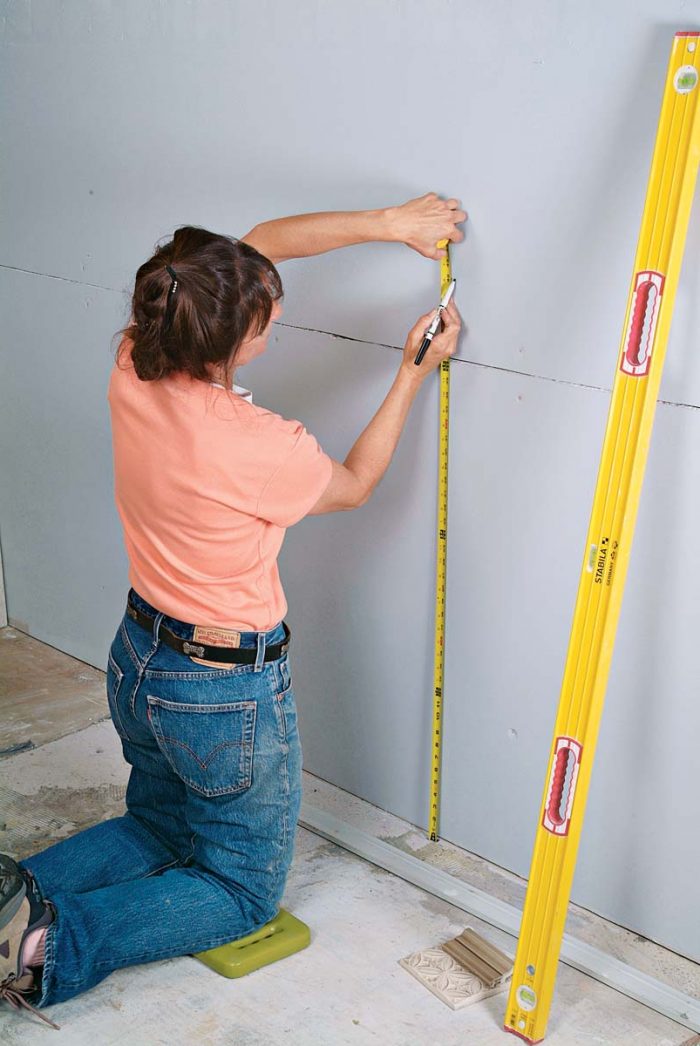 Make a mark on the wall at the top measurement you’ve chosen for your wainscoting.
