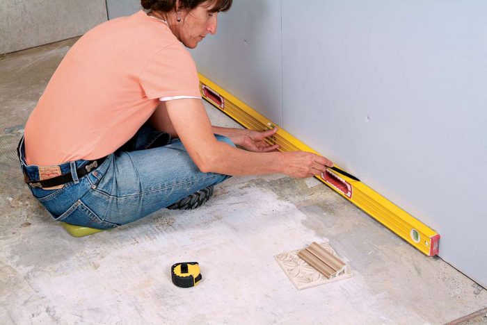 Make a level line across the wall at the grout joint to locate the ledger board.