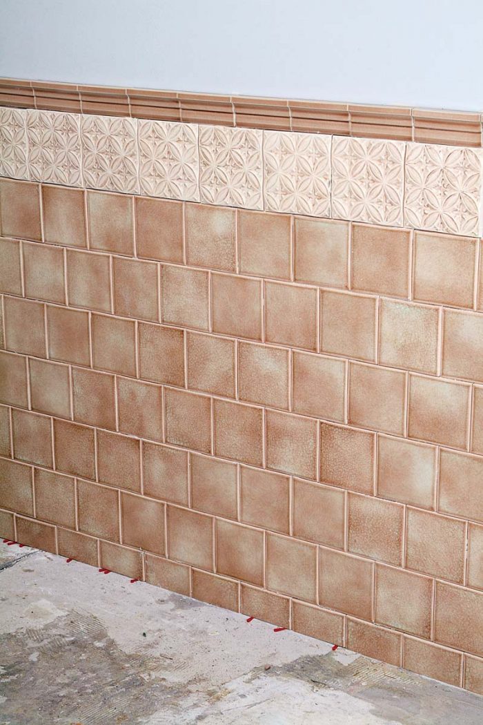 Tiled wainscoting with decorative relief tile and crown piece.