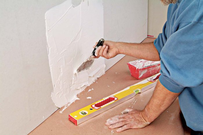 Flatten the wall by filling hollows with quick-setting wall patch compound.