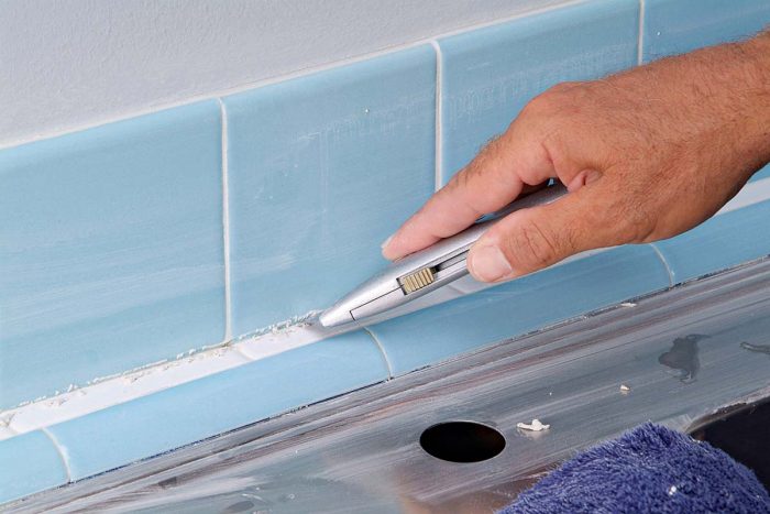 用美工刀清理后挡板和柜台瓷砖之间的接缝处的任何浆液。