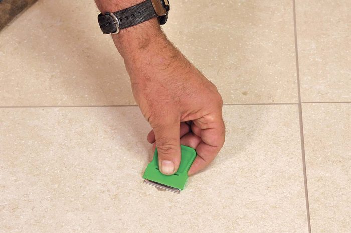 The next day, use a paint scraper to easily remove any grout from the surface of the tile.