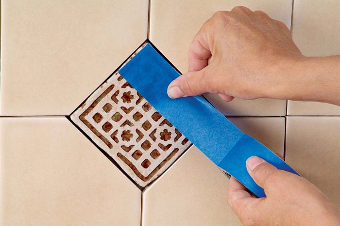 Apply tape on embossed areas of decorative tile to keep grout out of the design.