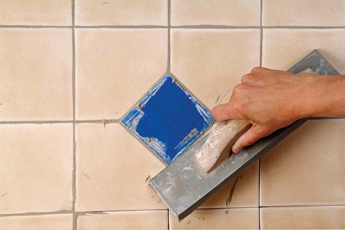 Grout as usual. Use care and avoid dislodging the tape.