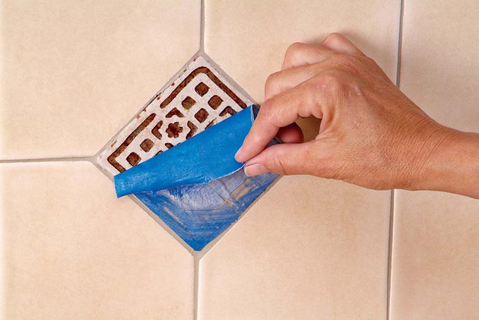 After grouting and polishing, remove tape from embossed tiles.