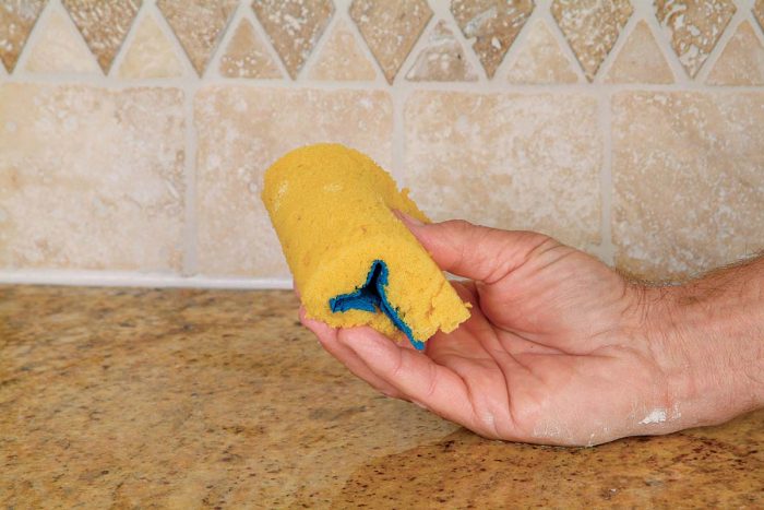 Use a damp folded sponge to smooth the joint and remove excess caulk.