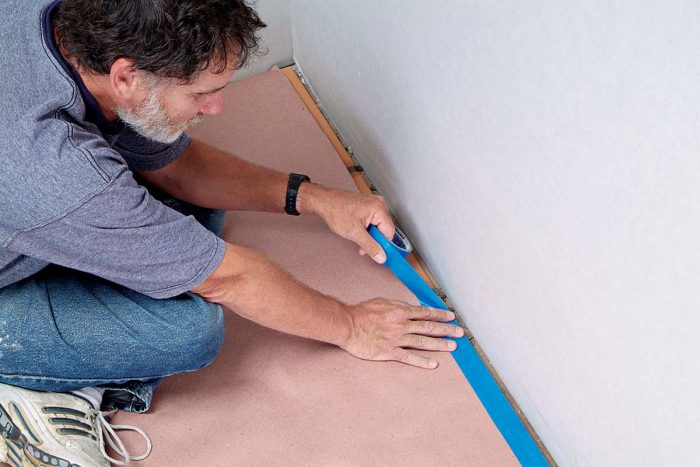 Before caulking a floor, use blue tape and paper to protect the perimeter.
