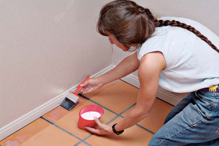 Wipe the sealer on evenly, coating the tile face and grout joints with a damp paintbrush.
