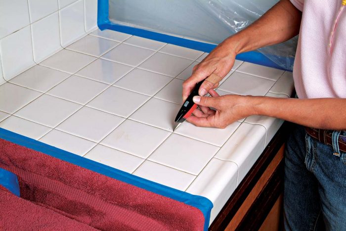 A utility knife can remove softer grout. Use both hands to steady the knife.