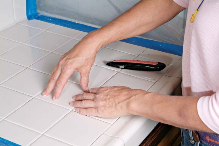 Fit the tile into place and use your fingers to check that it is flush with adjacent tiles.