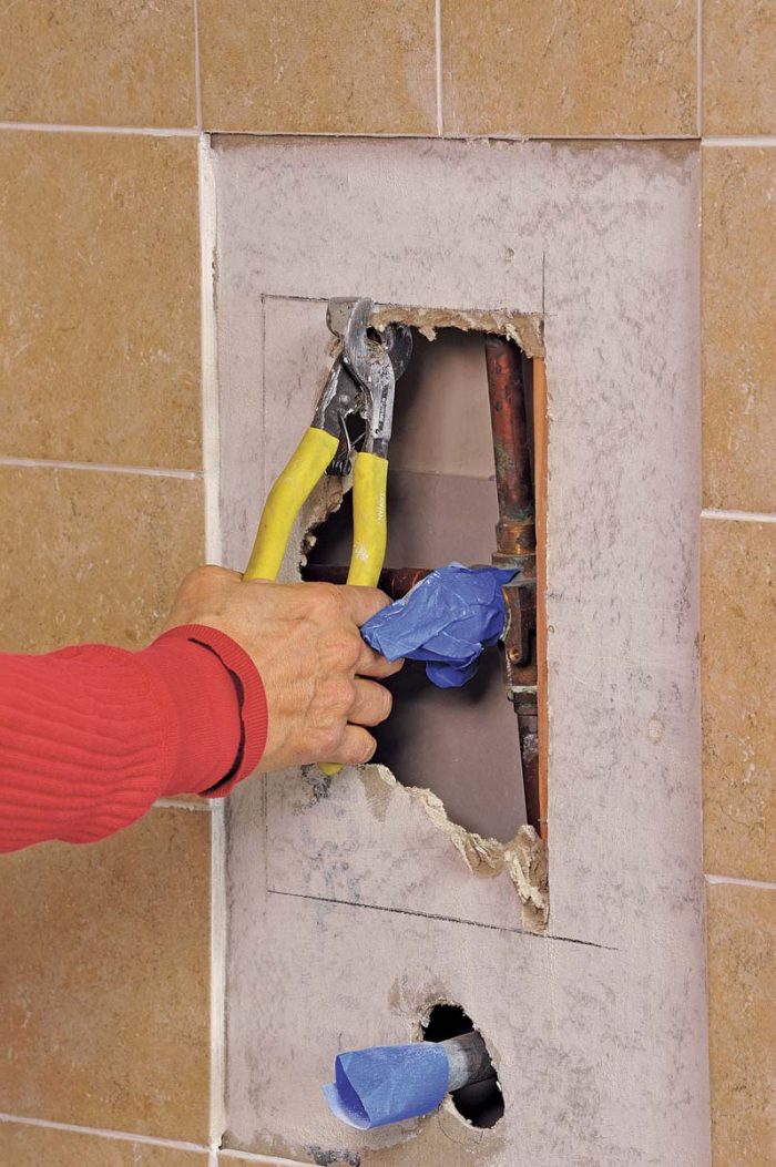 Tile nippers come in handy in these awkward places to remove the backerboard up to your lines.