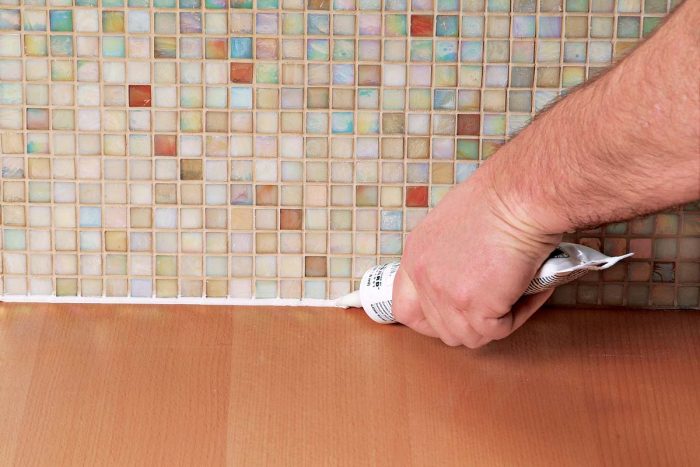 A small bead of caulk, color matched to the grout, will keep that joint flexible.