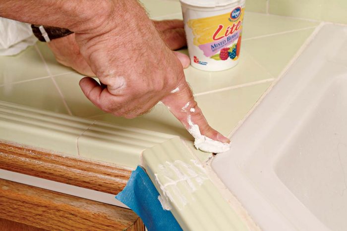 Spread the grout into the joint with a gloved or naked finger.