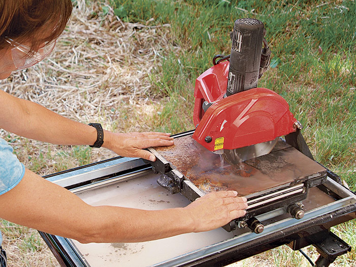 Feed the tile smoothly through the saw.