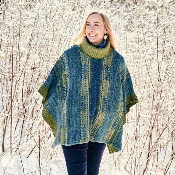 Image of a woman in a green and blue shawl against a backdrop of snowy trees