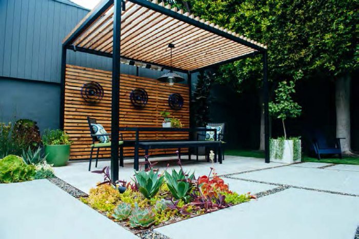 Pergola and table with large concrete pavers and plants