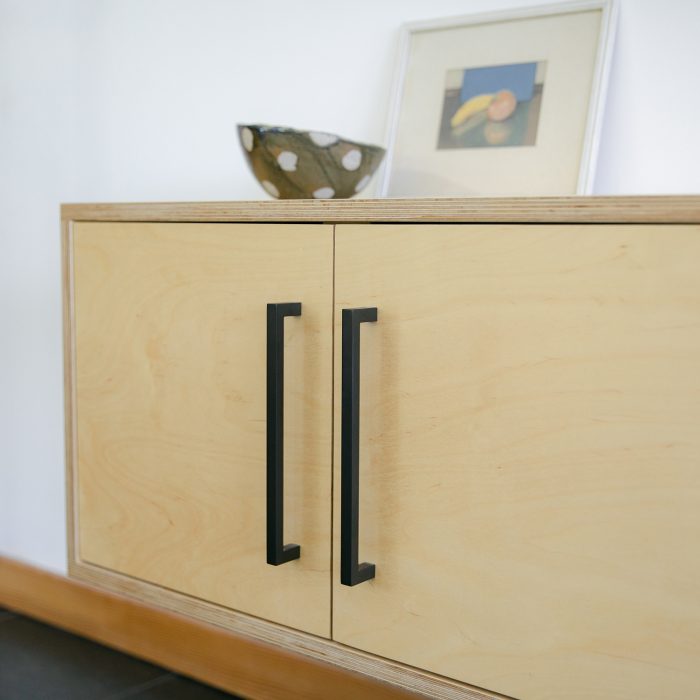 Black handles on cabinets made of light wood