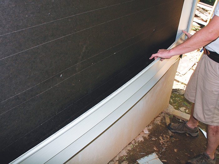 Bend vinyl siding panel to fit between J channels