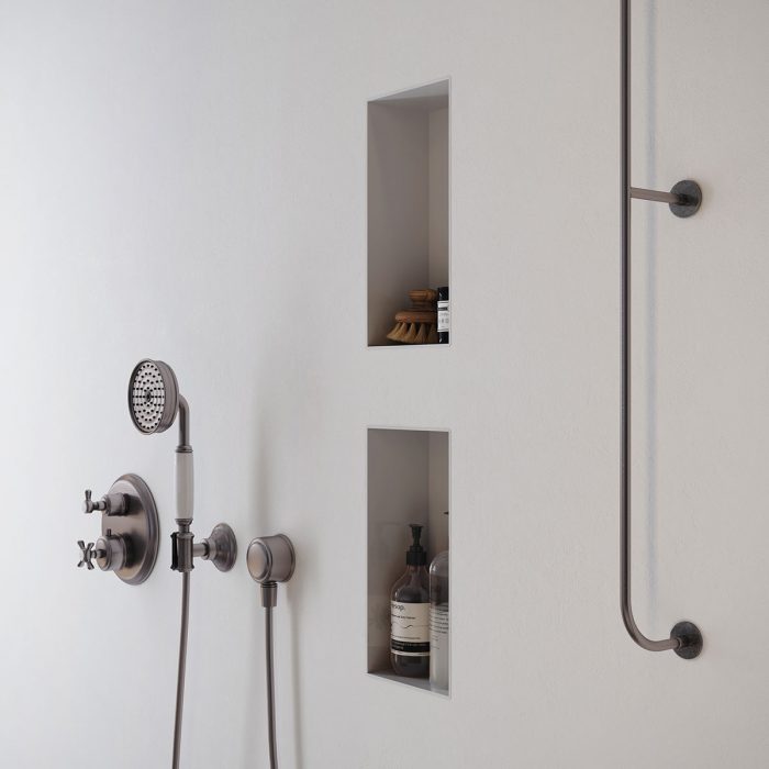 A white shower with inset bathroom containers