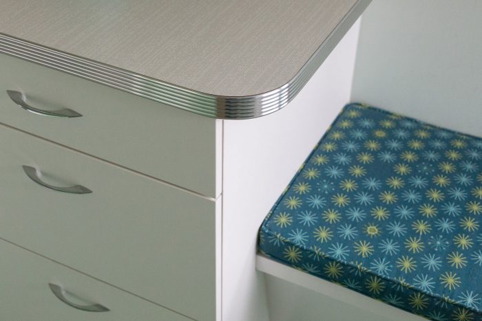 Close up of a laminate countertop next to a cushioned bench