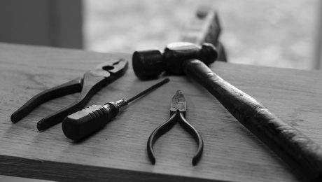 Black and white photo of four hand tools