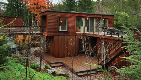 A brown modular home nestled among trees